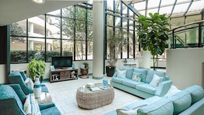 A spacious living area with a large window, a television, and comfortable seating.