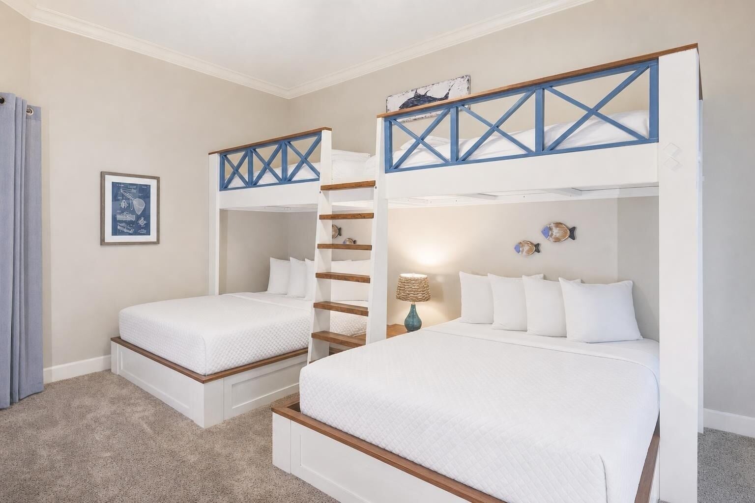 A hotel room with two bunk beds, a small table with a lamp, and a framed picture on the wall.