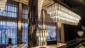 Un hall d’entrée luxueux, agrémenté de grands lustres, d’un comptoir de réception et d’un guichet d’enregistrement.