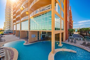 A hotel with a swimming pool, multiple balconies, and a clear sky. - Phoenix Gulf Shores 1903-1 1 Bedroom Condo (Gulf Shores)