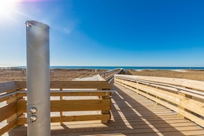 Walk along the boardwalk to the ocean's edge, where the sandy landscape meets the sea.