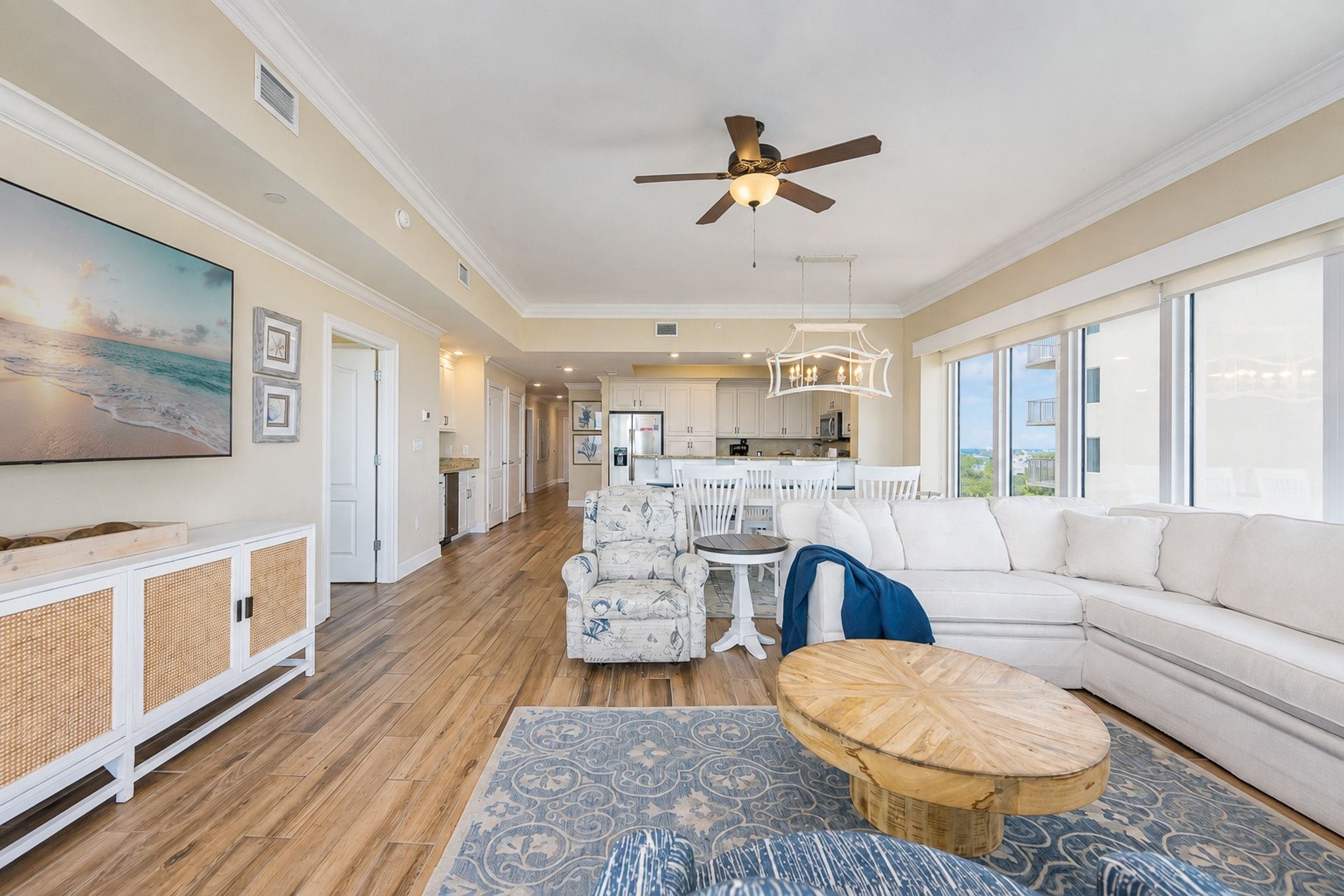 A spacious living room with a large sofa, a coffee table, and a dining area with chairs.