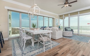 Enjoy meals at the large dining table surrounded by comfortable chairs, with a view of the ocean and beach.