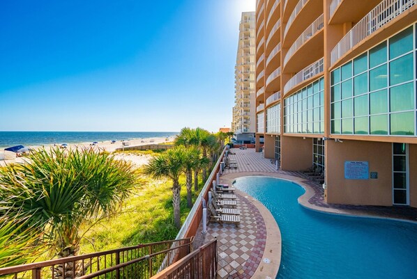 Un hotel con piscina, vista al mar y cielo despejado.