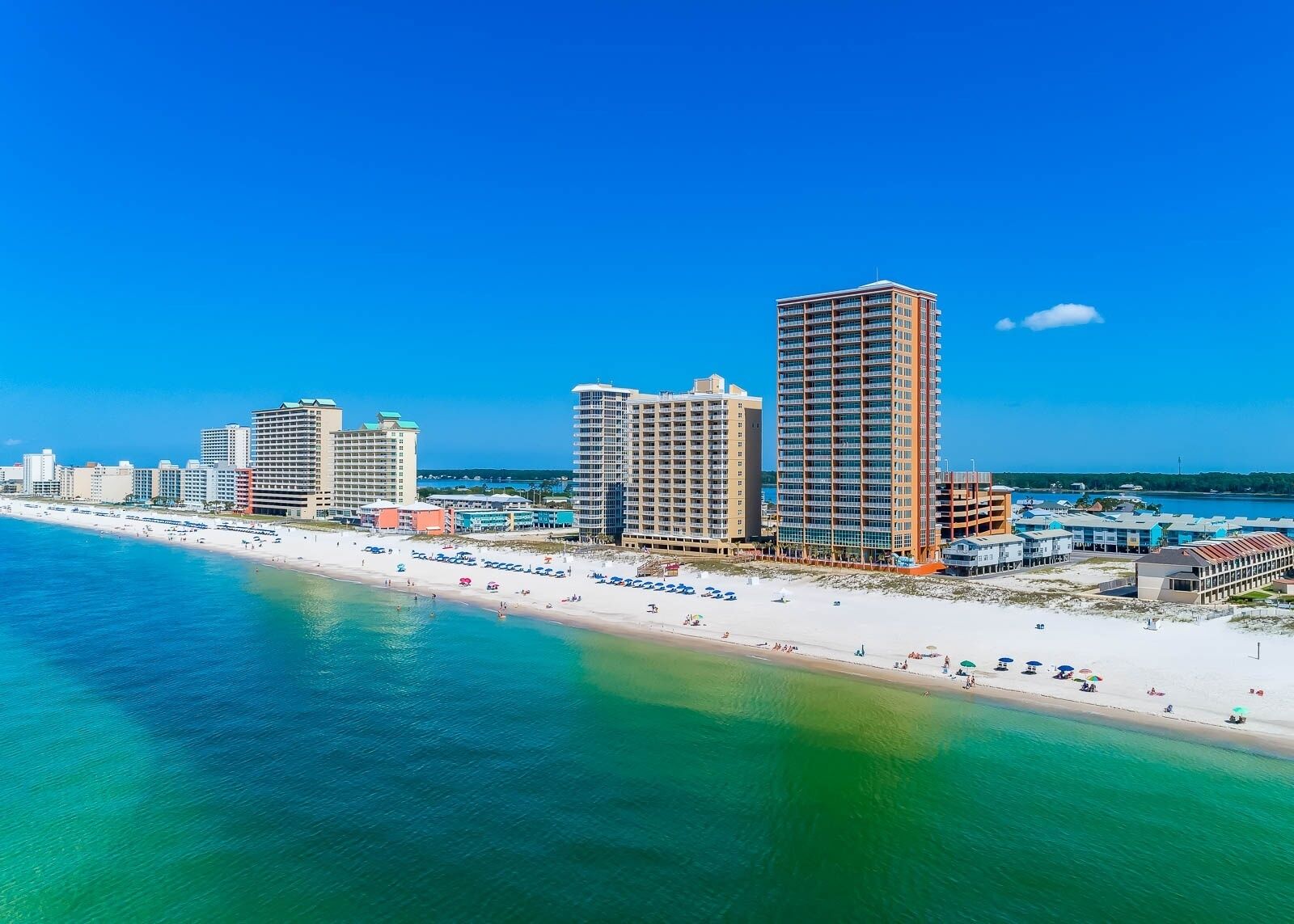 Eine Küstenstadt mit Hochhäusern, einem Strand und blauem Himmel.