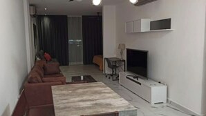 A modern living room with a sofa set, a coffee table, and a flat-screen TV mounted on the wall. - Dow Town Luxury Loft  (Monterrey)
