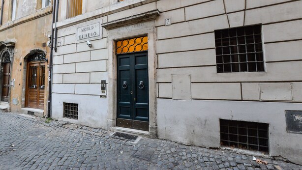 A building with a black door, a plaque reading "Vicolo Riccardo 7", and a small window with a grid pattern. - Navona Vita Suites (Rome)