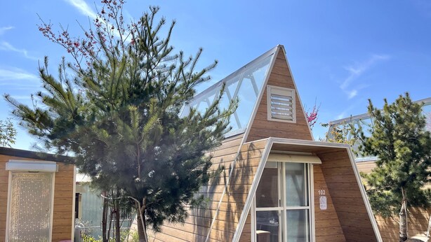 Um edifício moderno com telhado triangular e janelas amplas.