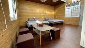 Quarto pequeno com duas camas, uma mesa e um banco.