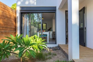 Una casa moderna con un cerramiento de vidrio corredero que da a un comedor.