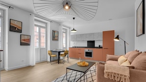 Un salon moderne avec un canapé, une table basse et un coin repas.