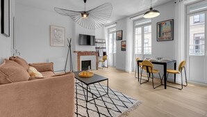 Un salon moderne avec un canapé, une table à manger et des chaises, une cheminée et des œuvres d’art accrochées aux murs.