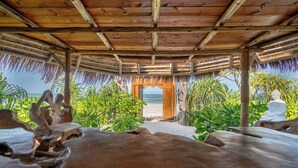 A wooden structure with a thatched roof, leading to a beach. - Sensations Eco-Chic Hotel (Pwani Mchangani)