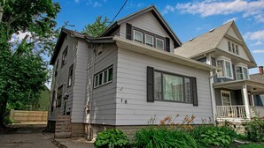 A two-story house with a front porch, a garage, and a well-maintained garden. - Chic Two Bedroom near Buffalo (Buffalo)