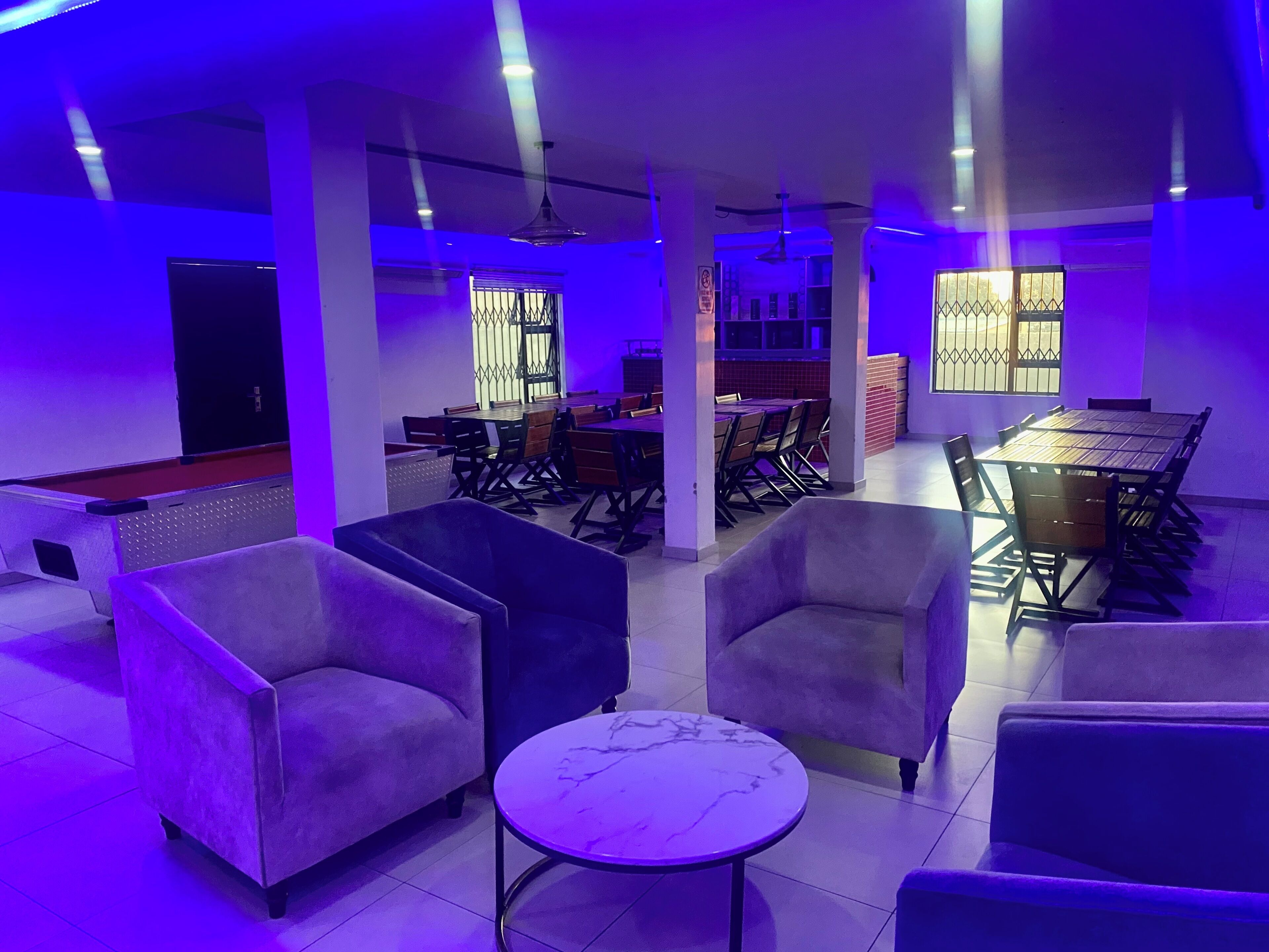 A modern interior with sofas, a marble table, and a dining area with chairs and a table.