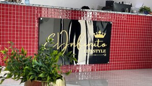 Una zona de recepción con pared de baldosas rojas y un letrero que dice "El Finito Lifestyle".