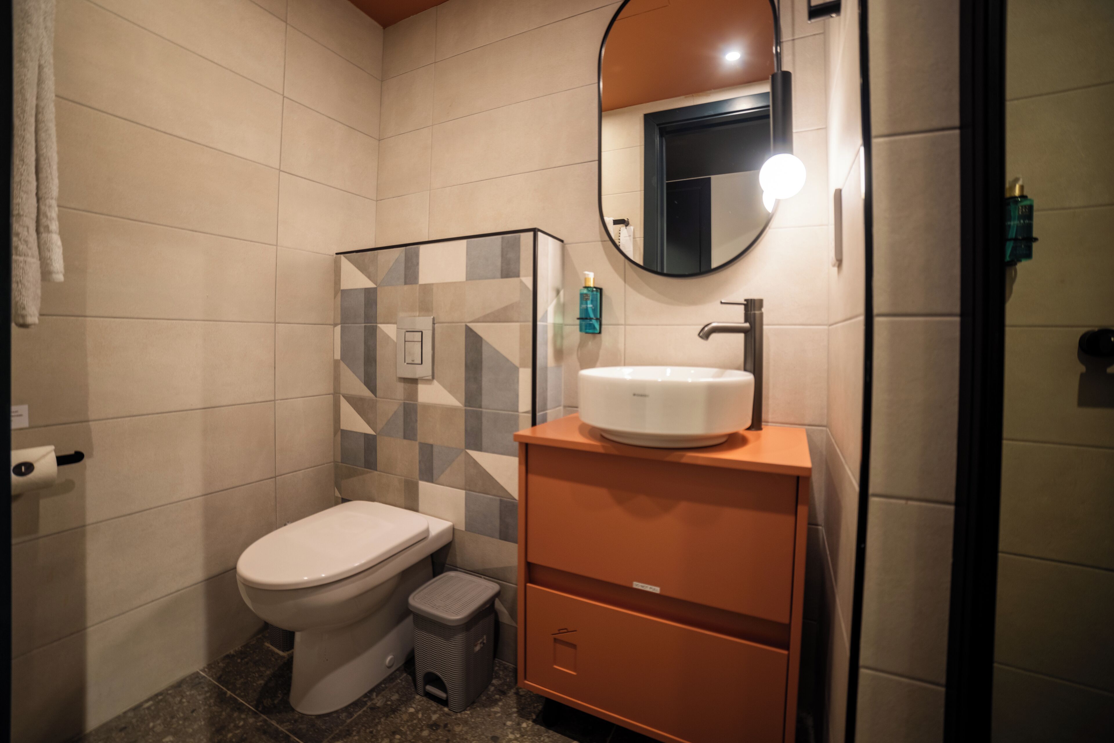 Un baño moderno con inodoro, lavabo y espejo.