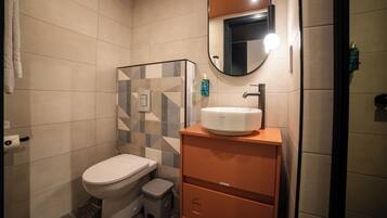 Un baño moderno con inodoro, lavabo y espejo.