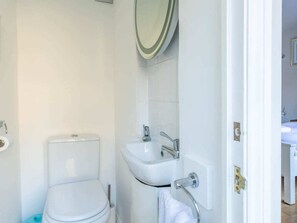 Une salle de bain avec des toilettes, un lavabo et un miroir.