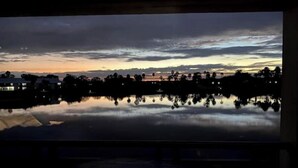A nighttime view of a lake with reflections of buildings and trees.
