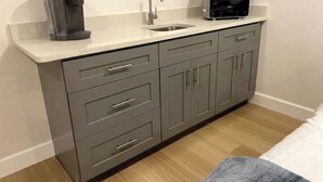 A compact kitchen with a sink, a coffee maker, and a microwave.