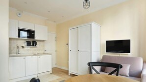A compact living space with a kitchenette, a dining area, and a seating area.