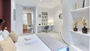Una habitación de hotel moderna con una cama grande, un escritorio y un armario.
