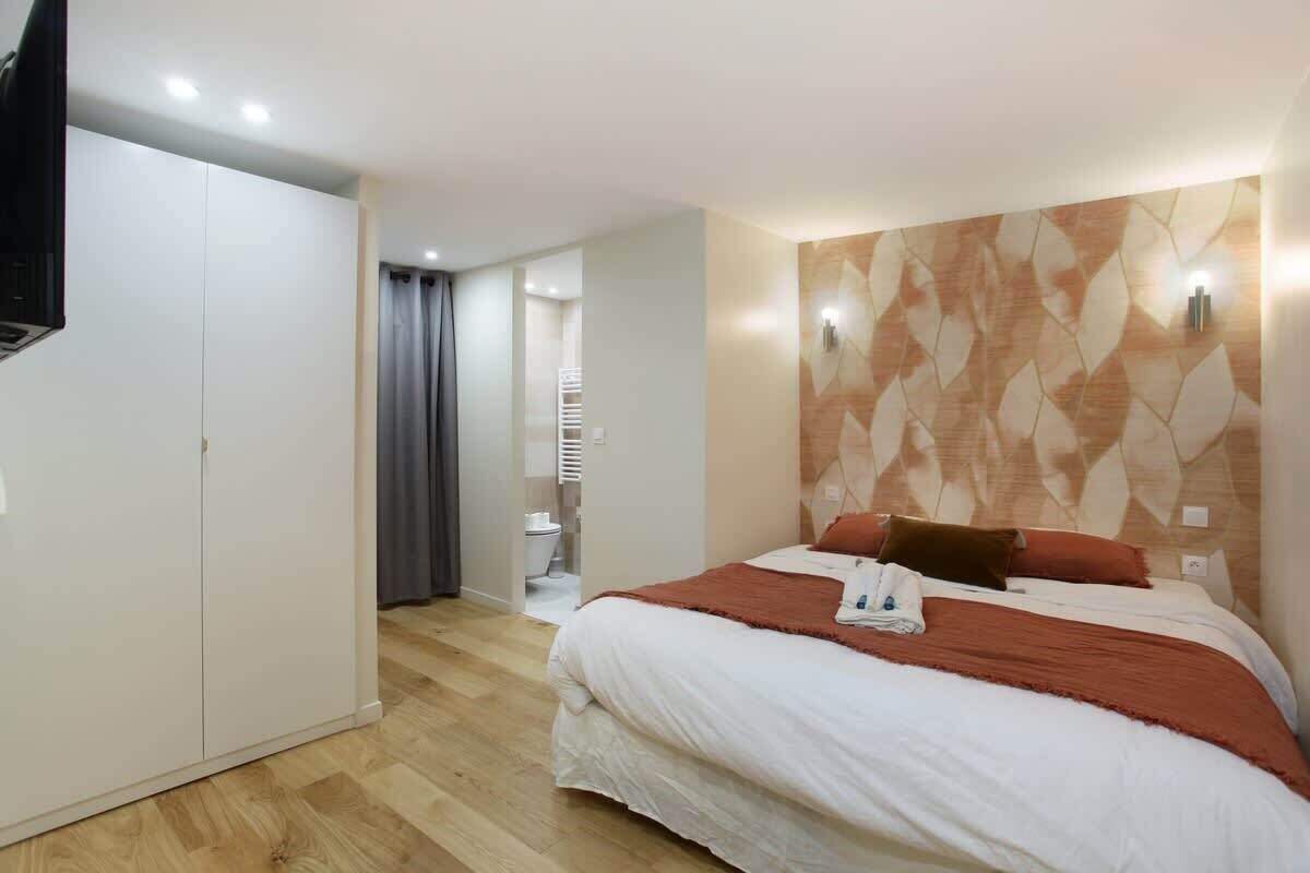 Una habitación de hotel con cama, armario, baño y televisor.