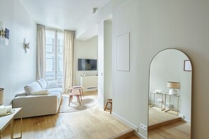 Una sala moderna con sofá, mesa de centro y televisor.