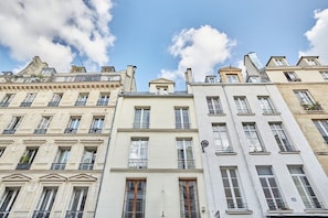 A row of classic European-style buildings with uniform facades, large windows, and balconies.