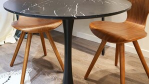A round table with a black marble top, two wooden chairs, and a metal shelf unit against a white wall. - Modern Suite  Center of Paris Montmartre (Paris)