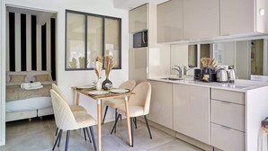 A modern kitchen with a dining area, featuring a sofa, a table set for two, and a microwave above the counter. - Cosy & new apartment Le Marais/Place des Vosges (Paris)