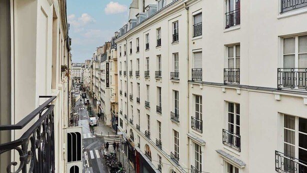 A narrow street lined with multi-story buildings, featuring balconies and a mix of architectural styles. - Charming apartment Center of Paris/Montorgueil (Paris)