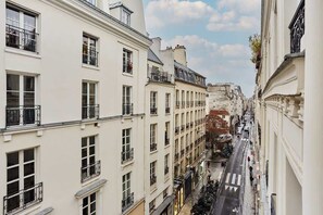 Eine enge Straße, gesäumt von mehrstöckigen Gebäuden mit Balkonen und Fenstern.