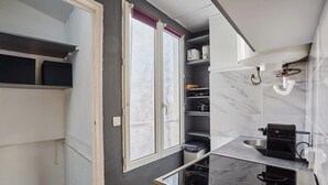 A compact kitchen with a built-in stove, a window, and a sink.