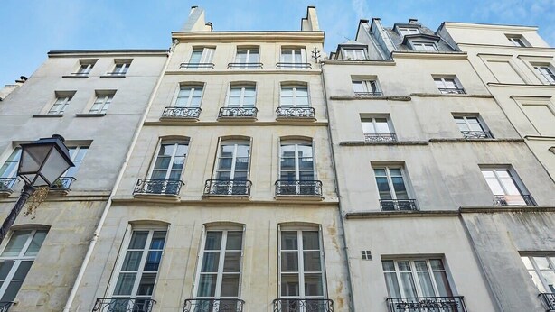 A multi-story building with a classical architectural style, featuring symmetrical windows and ornate balconies.