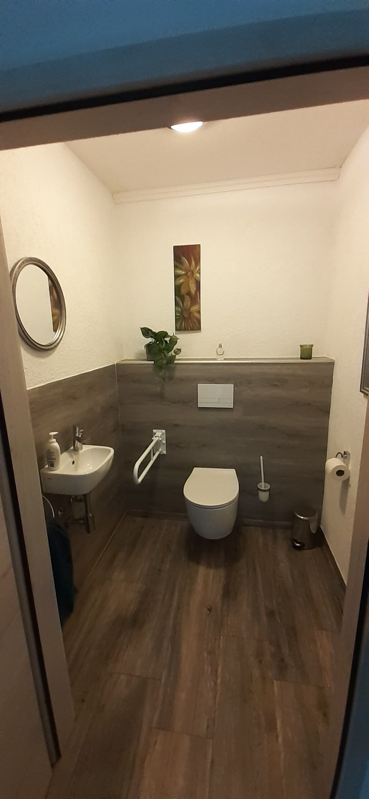 Une salle de bain avec des toilettes, un lavabo et un miroir.
