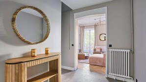 A hallway with a wooden console table, a large mirror, and a radiator. - New and Exceptional apartment Madeleine/Concorde (Paris)