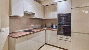 A modern kitchen with a built-in microwave, oven, and sink. - Elegant Apartment St Germain des prés Luxembourg Park (Paris)
