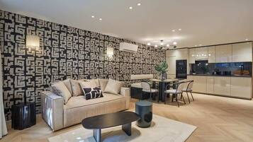 Un salon moderne avec un mur à motifs, un canapé, une table basse et un coin repas comprenant des chaises et une table.