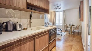 A modern kitchen with wooden cabinets, a sink, and a dining area with a table and chairs.