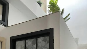 A modern staircase with a minimalist design, featuring a glass door with a leaf pattern. - Duplex T3 Climatisé, Plein Centre Terrasse vue mer (La Ciotat)