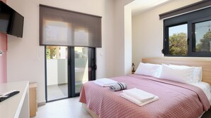 Ein Schlafzimmer mit einem Bett, einem Fernseher, einer Schiebetür und einem Fenster.