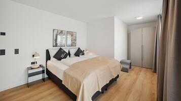 Ein modernes Schlafzimmer mit Bett, Nachttischen, Kleiderschrank und Spiegel.