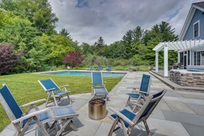 A backyard with a pool, lounge chairs, and a pergola. - Stockbridge Retreat w/ Pool & Hot Tub! (Stockbridge)