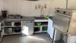 A kitchen with a stove, sink, dishwasher, and refrigerator. - Auberge de jeunesse HI Millau La Maladrerie (Millau)