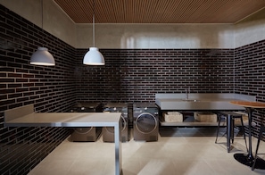 Una cocina moderna con salpicadero de ladrillo, electrodomésticos de acero inoxidable e iluminación colgante.