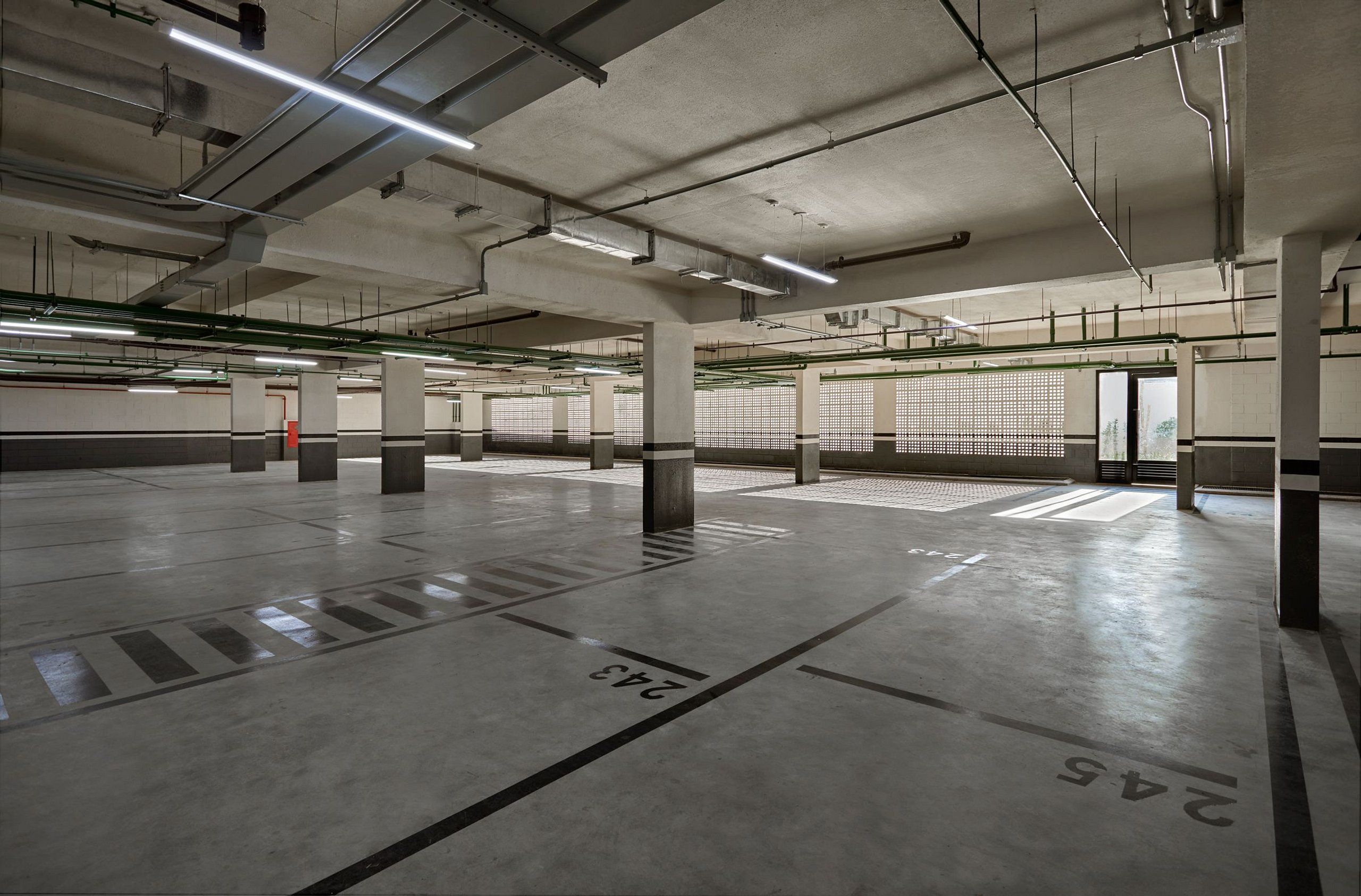 Eine Parkgarage mit Betonböden, markierten Stellplätzen und tragenden Säulen.