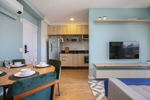 A modern kitchen with wooden cabinets, a microwave, and a built-in oven. - Expand Pinheiros (São Paulo)