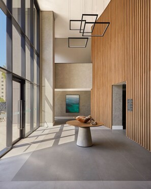 A modern interior with a round table, a painting, and a wooden wall. - Expand Pinheiros (São Paulo)